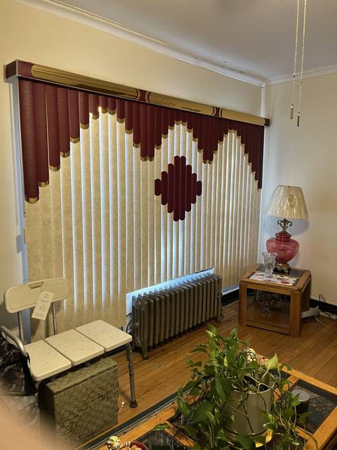 Cream blinds with a burgundy diamond pattern and scalloped valance